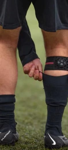 Player fastening the Footbar tracker strap above the sock
